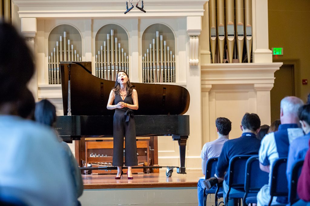 Student singing in front of an organ